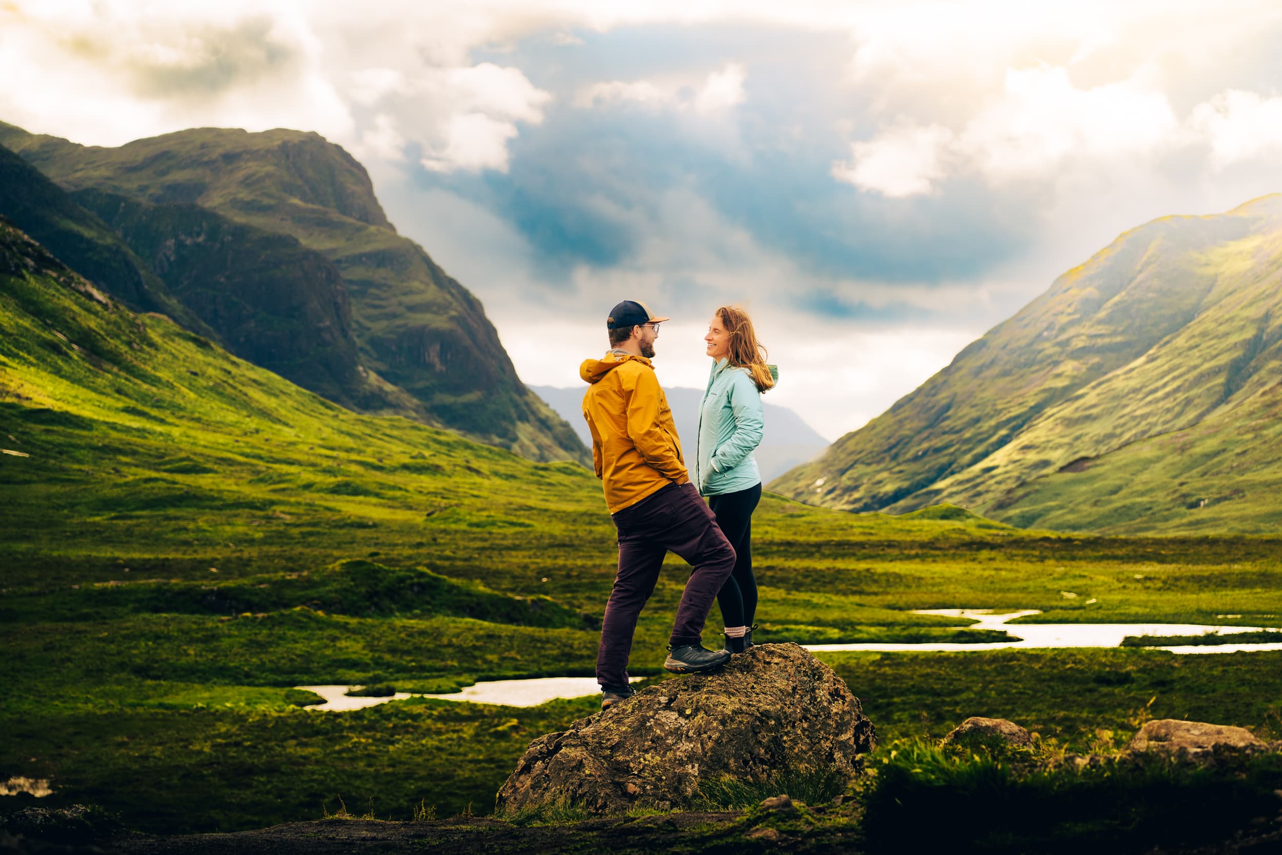 couple standing on a rock at the three sisters viewpoint in Glencoe Scotland