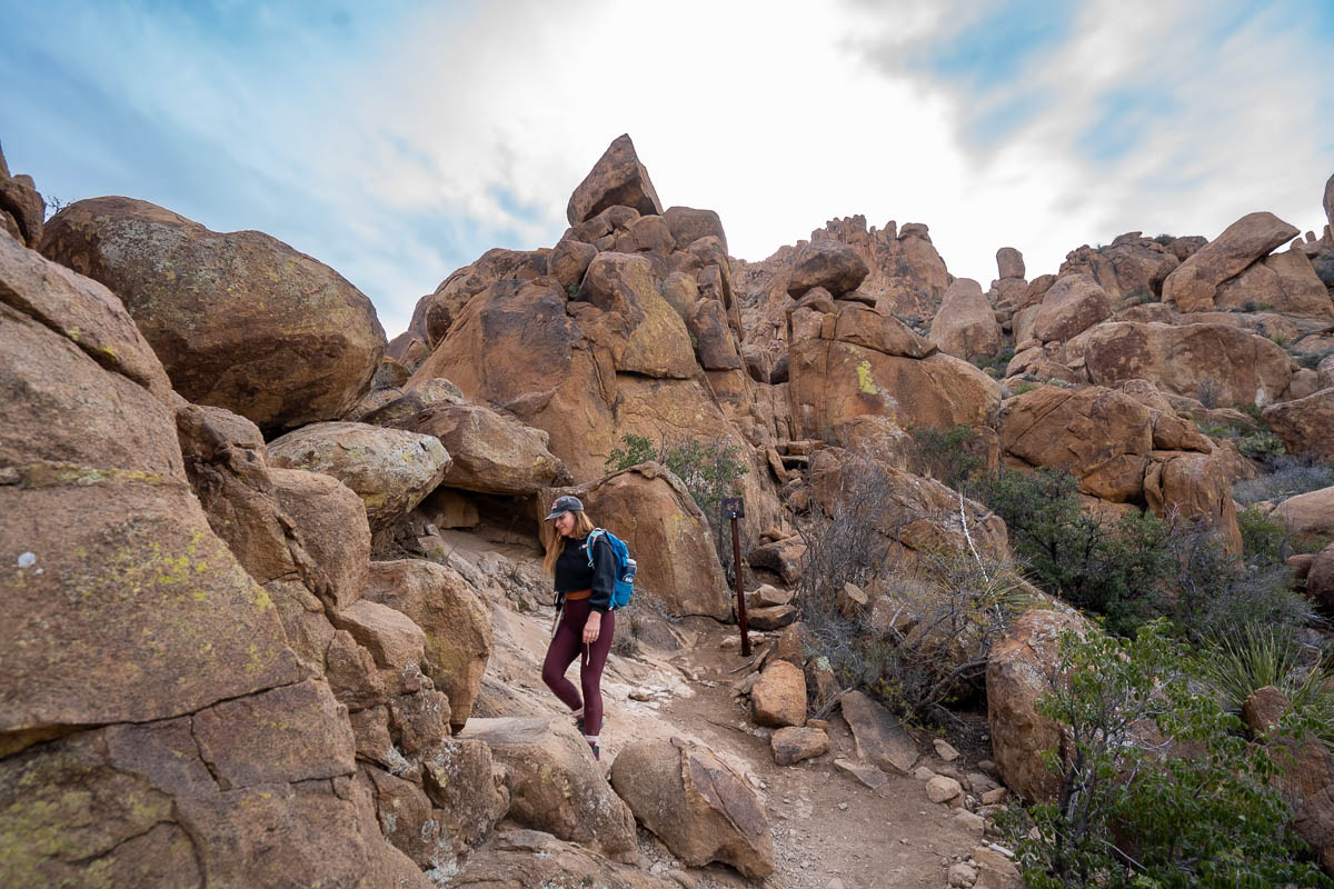 Woman hiking through boulders along the Balanced Rock Trail in Big Bend National Park in Texas