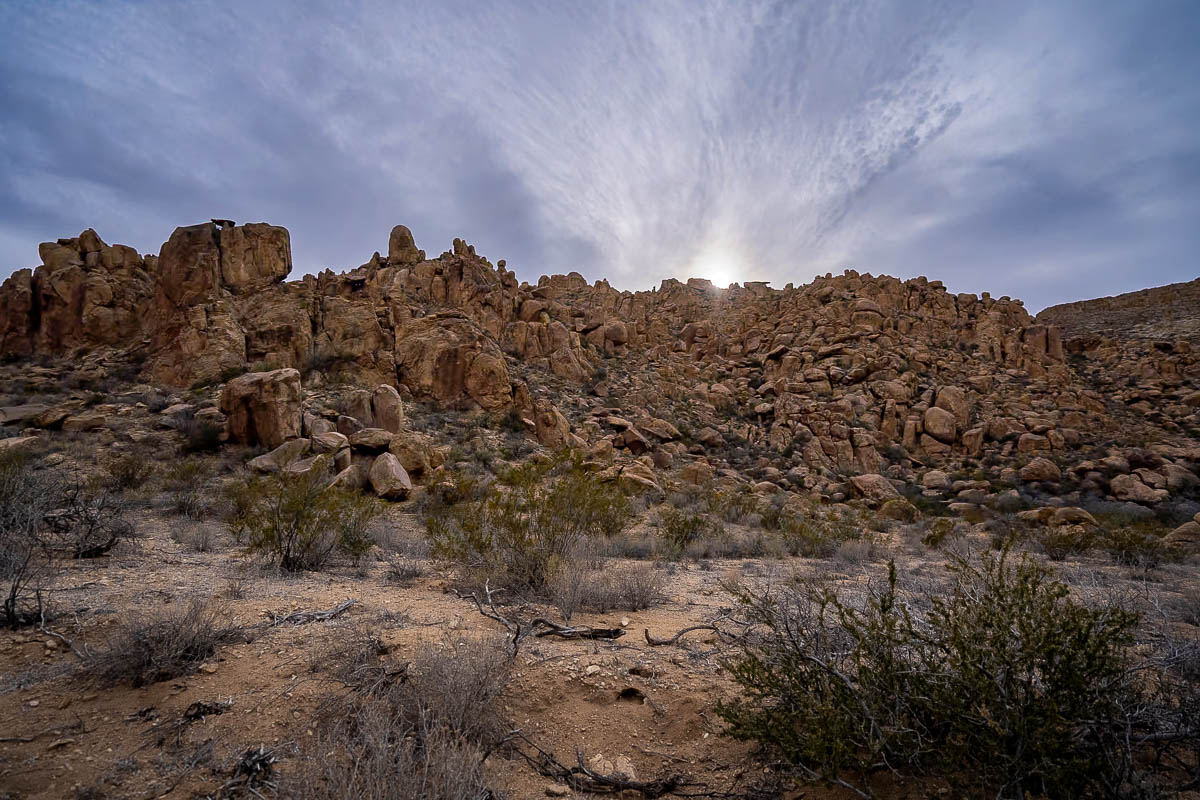 Sun setting behind a cliff of boulders along the Balanced Rock Trail in Big Bend National Park in Texas