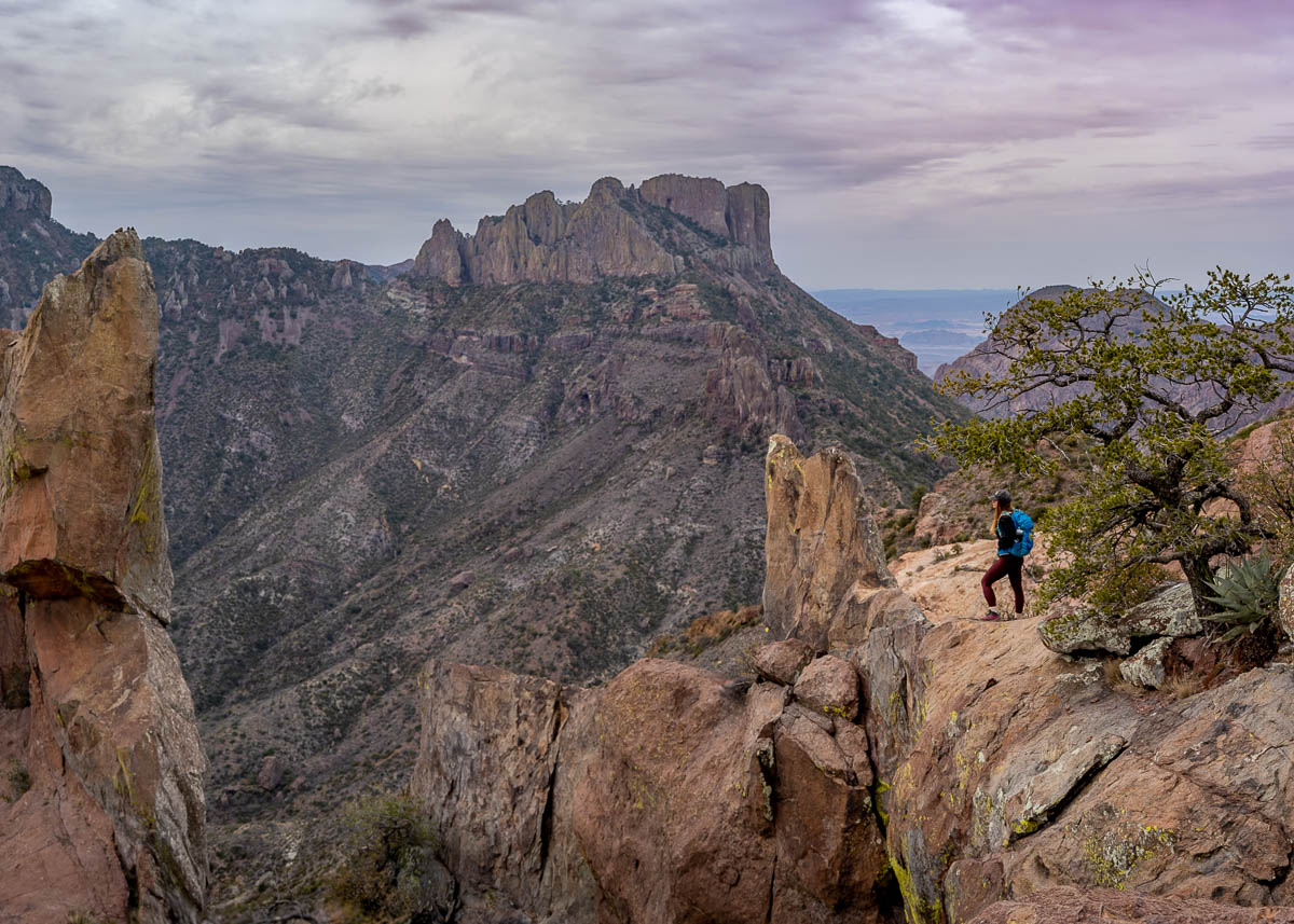 Woman standing on the edge of a cliff, overlooking Casa Grande in Big Bend National Park in Texas