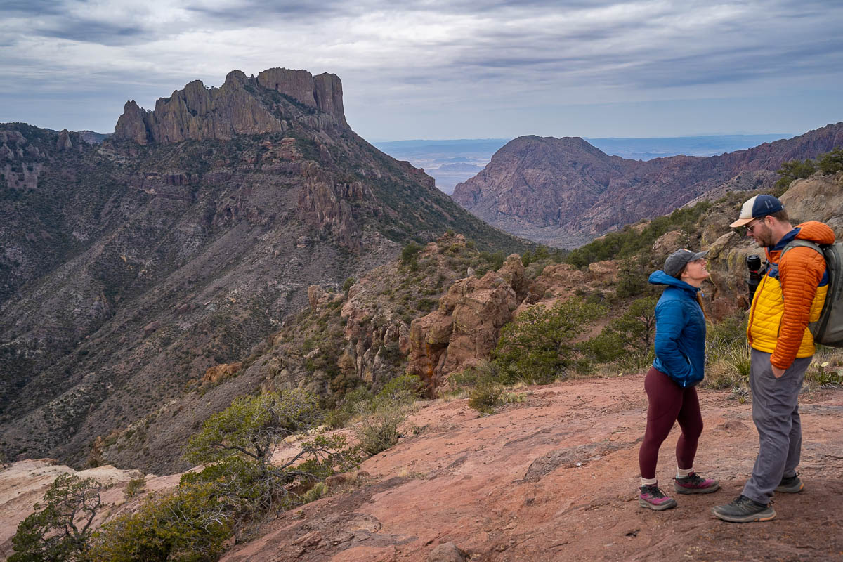 Couple standing with the Casa Grande Mountain in the background along the Lost Mine Trail in Big Bend National Park in Texas