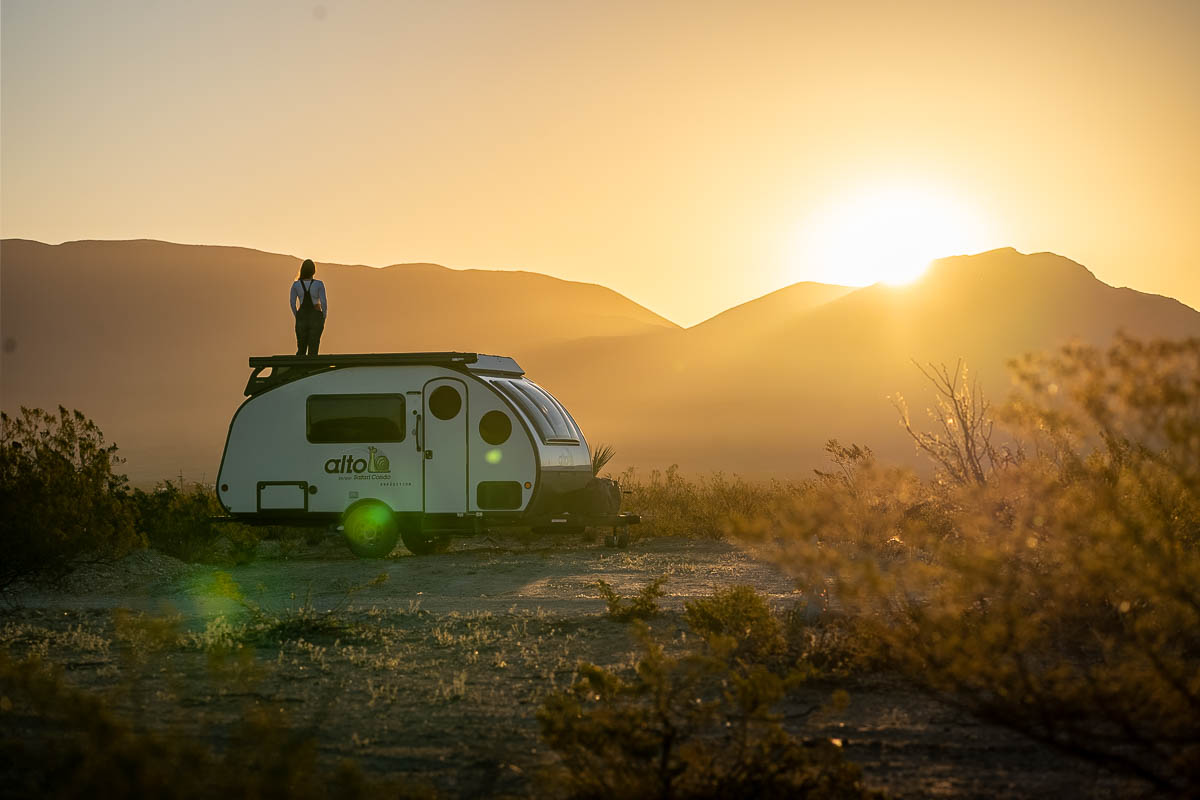 Woman standing on top of her Safari Condo Alto Expedition F1743 at sunrise in Telingua, Texas