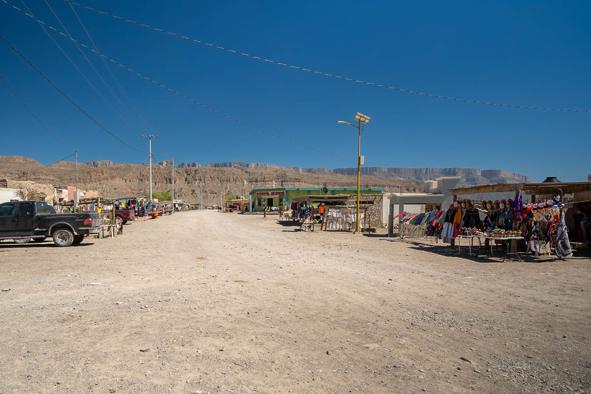 Vendors and stores lining a road in Boquillas del Carmen with canyon wall in the background in Mexico