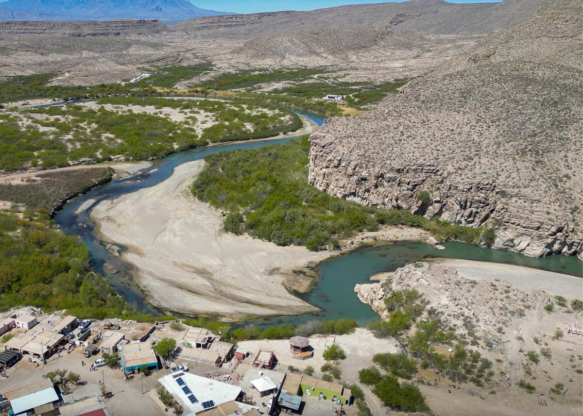 Buildings in Boquillas del Carmen, Mexico with the Rio Grande and mountains in the background