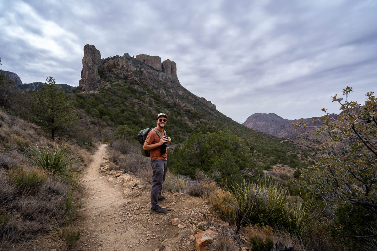 Man hiking along the Lost Mine Trail with the Casa Grande Peak in the background in Big Bend National Park in Texas