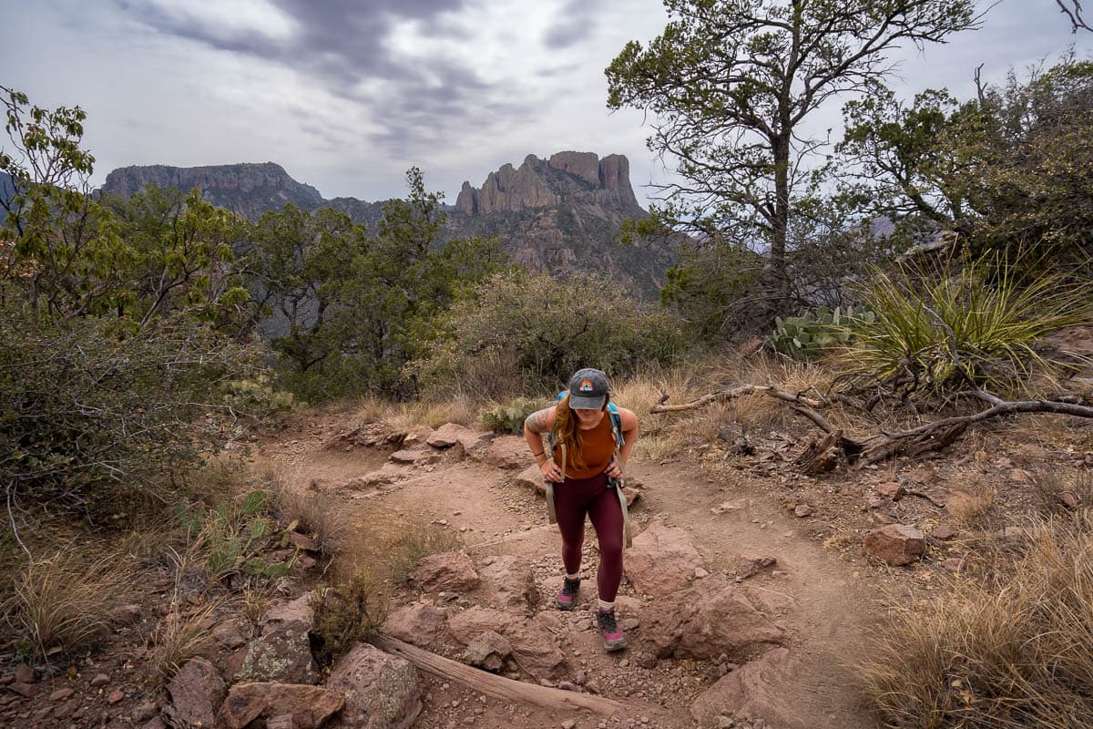 Woman climbing up stairs along the Lost Mine Trail with the Chisos Mountains in the background in Big Bend National Park in Texas