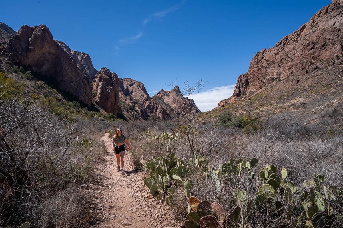 Woman walking along the Window Trail with the Chisos Mountains in the background in Big Bend National Park in Texas