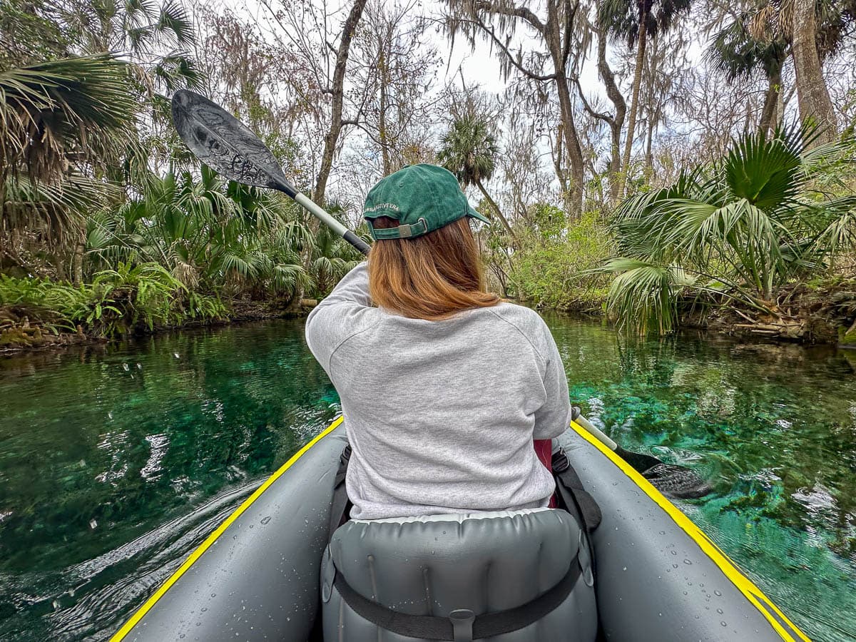 Woman kayaking with ferns in the background in Silver Springs State Park in Ocala, Florida