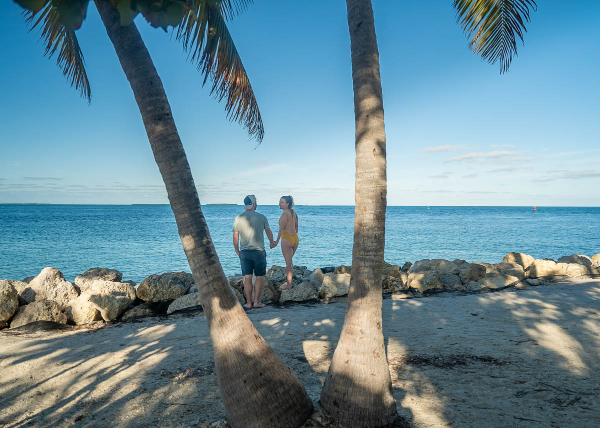 Couple standing on rocks at the Fort Zachary Taylor Beach in Key West, Florida 