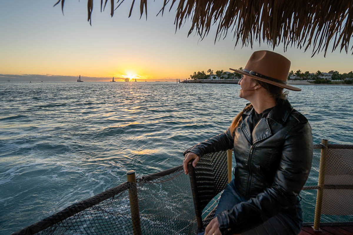 Woman sitting on a tiki boat at sunset near Sunset Key in Key West, Florida