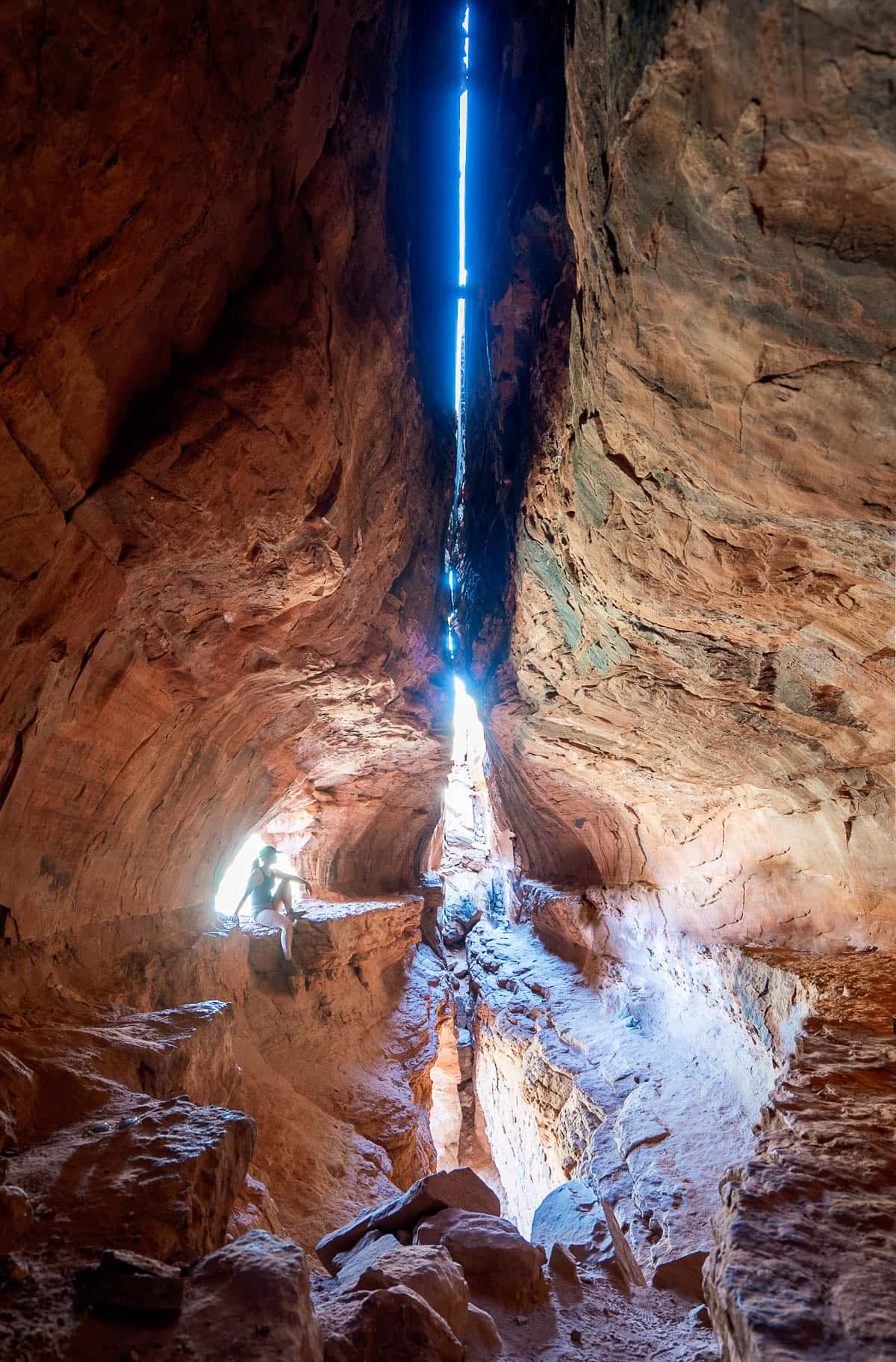 Woman sitting on a ledge in the Soldier Pass Cave along the Soldier Pass Trail in Sedona, Arizona