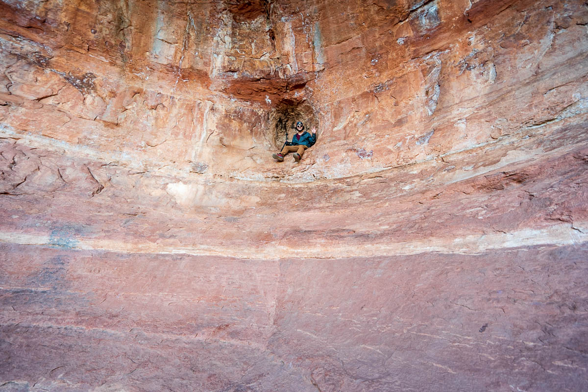 Man sitting in an indentation in the Birthing Cave in Sedona, Arizona