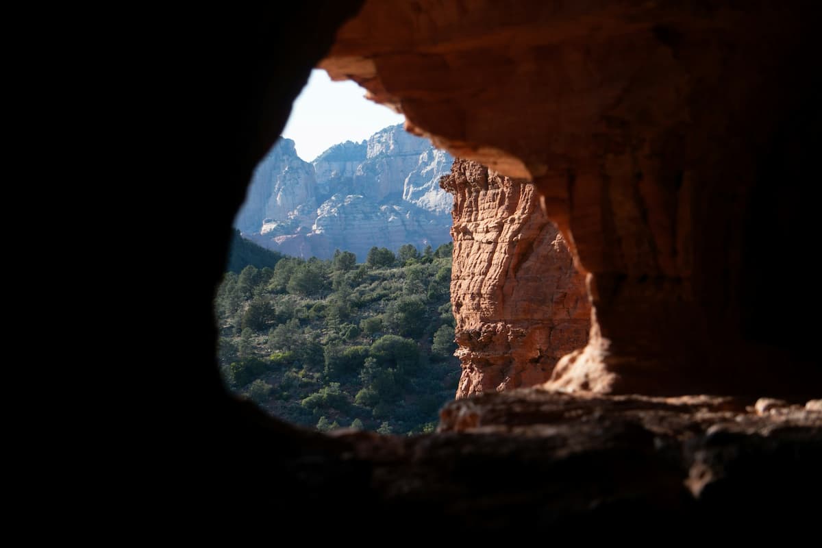 Window in the Soldier Pass Cave with red rock formations in the background along the Soldier Pass Trail in Sedona, Arizona