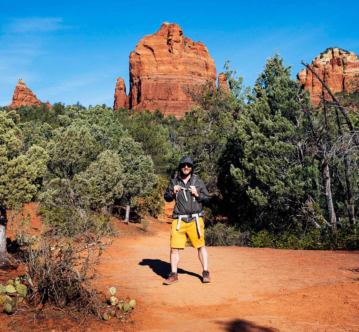 Man smiling in front of rock formations along the Soldier Pass Trail in Sedona, Arizona