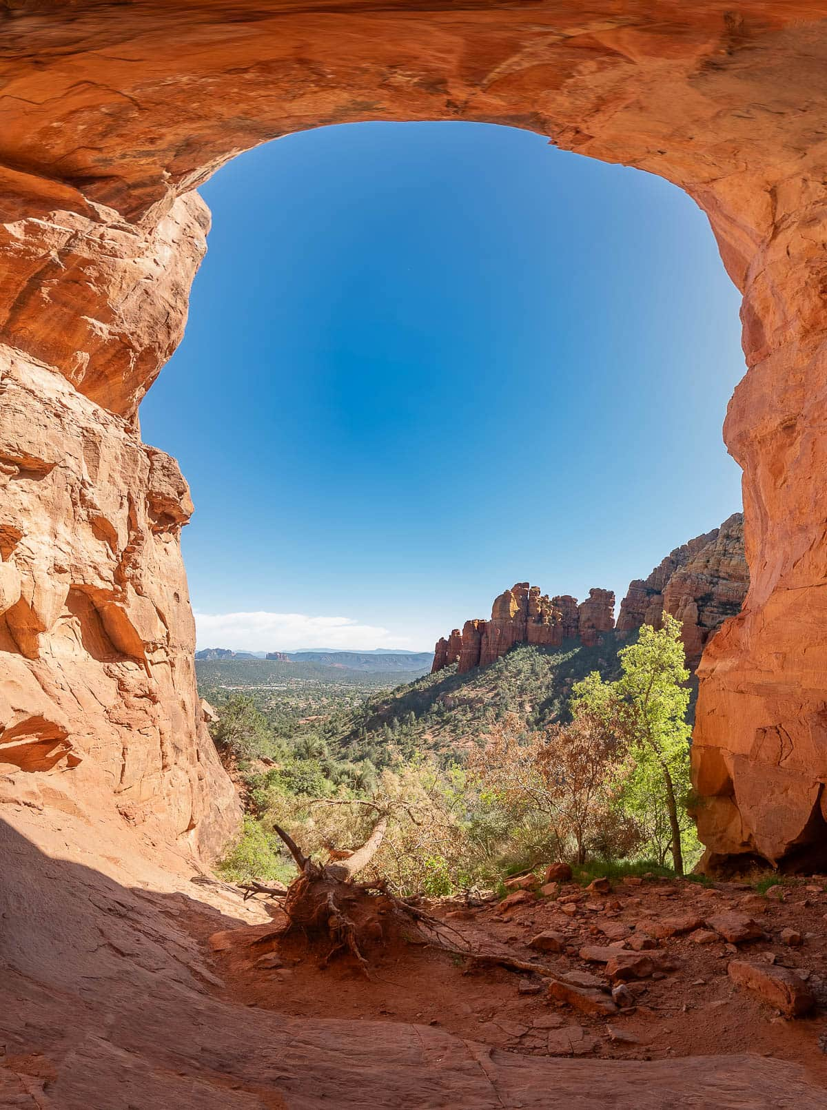 Opening of the Keyhole Cave with red rock formations in the background of Sedona, Arizona