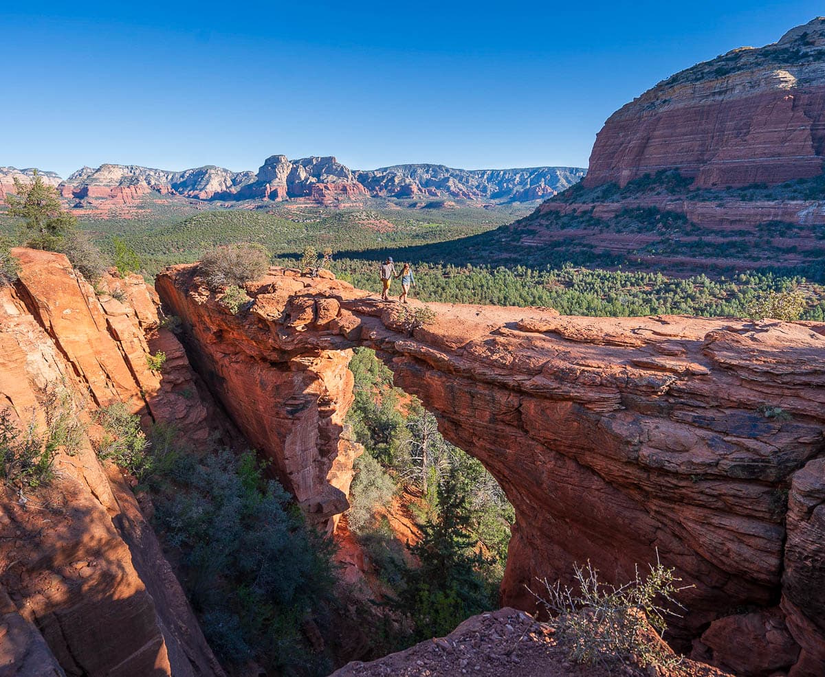 Couple holding hands and walking across Devil's Bridge in Sedona, Arizona