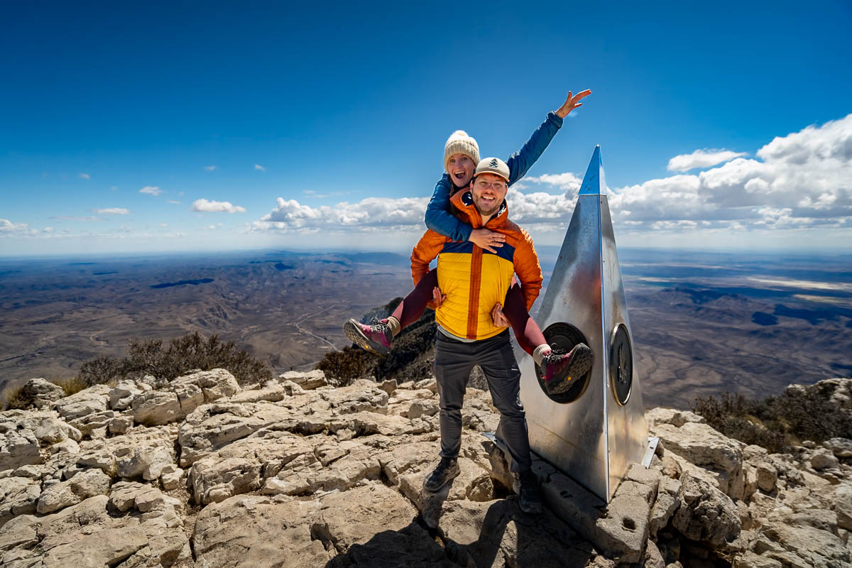 Couple standing next to a monument along the Guadalupe Peak Trail in Guadalupe Mountains National Park in Texas