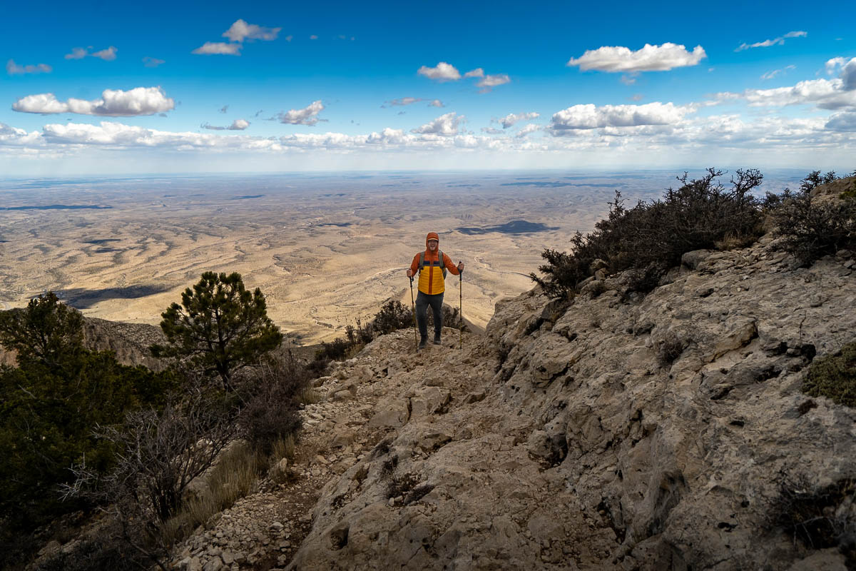 Man climbing a switchback along the Guadalupe Peak Trail with the Chihuahuan Desert in the background in Guadalupe Mountains National Park in Texas