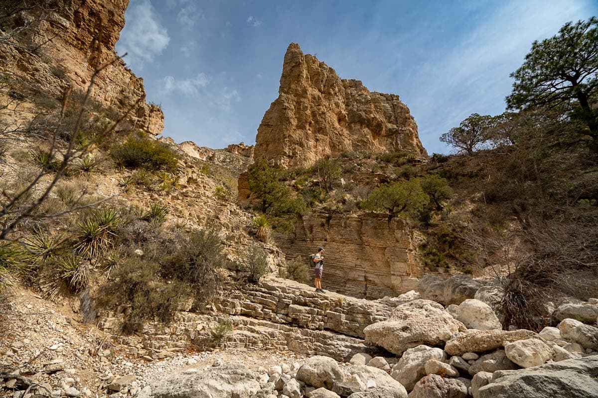 Man standing in front of a rock formation along the Devil's Hall Trail in Guadalupe Mountains National Park in Texas