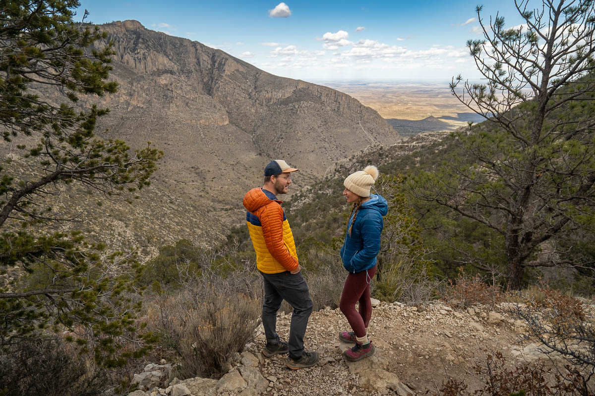 Couple standing along the Guadalupe Peak Trail with Hunter Peak in the background in Guadalupe Mountains National Park in Texas