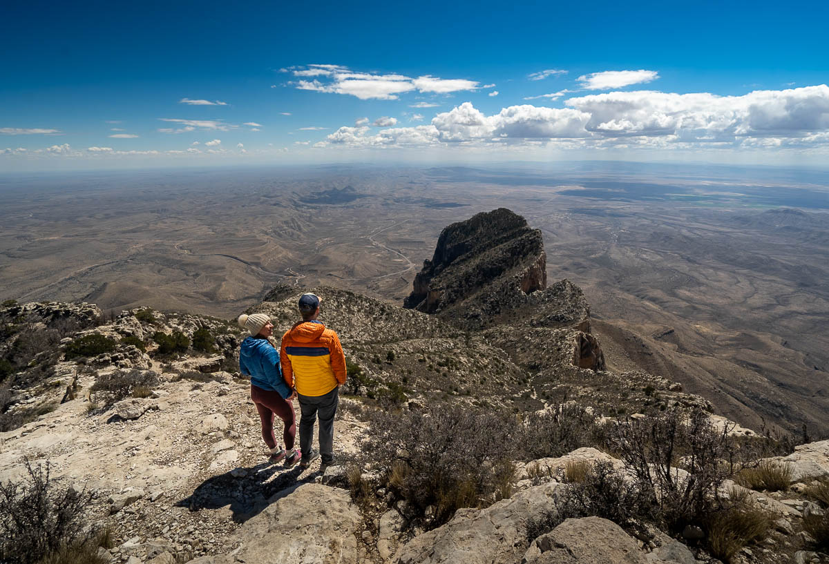 Couple holding hands along the Guadalupe Peak Trail, overlooking the El Capitan Mountain and the Chihuahuan Desert in Guadalupe Mountains National Park in Texas