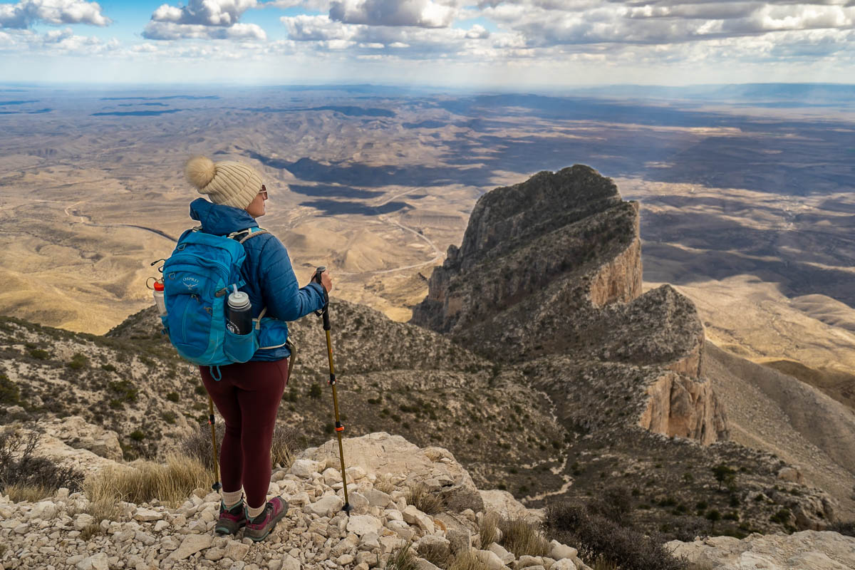 Woman standing at the summit of Guadalupe Peak, overlooking the El Capitan Mountain and the Chihuahuan Desert in Guadalupe Mountains National Park in Texas