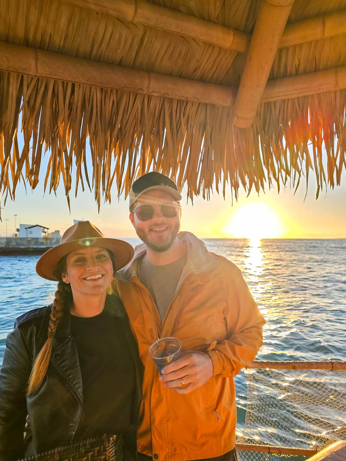 Couple smiling at sunset in a tiki boat near Sunset Key in Key West in the Florida Keys