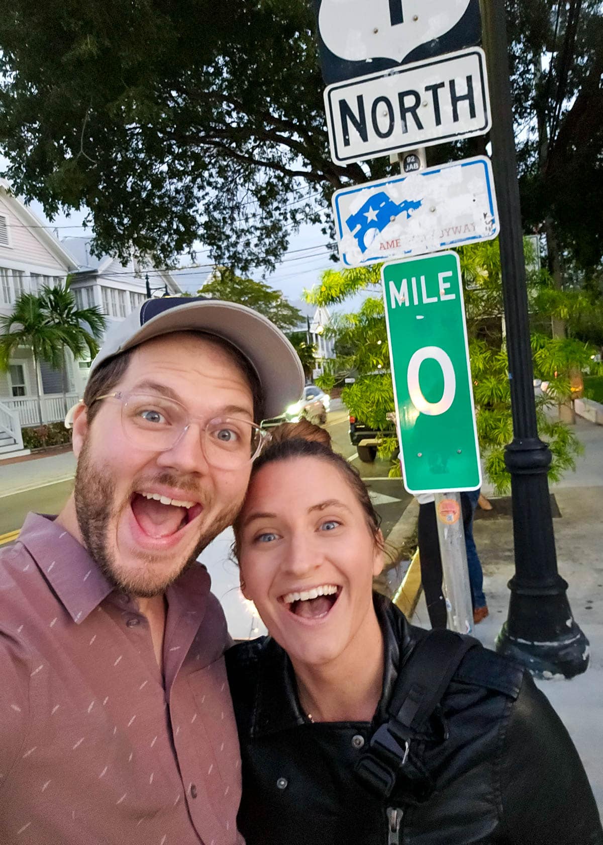 Couple smiling in front of the Mile 0 marker in Key West in the Florida Keys, Florida