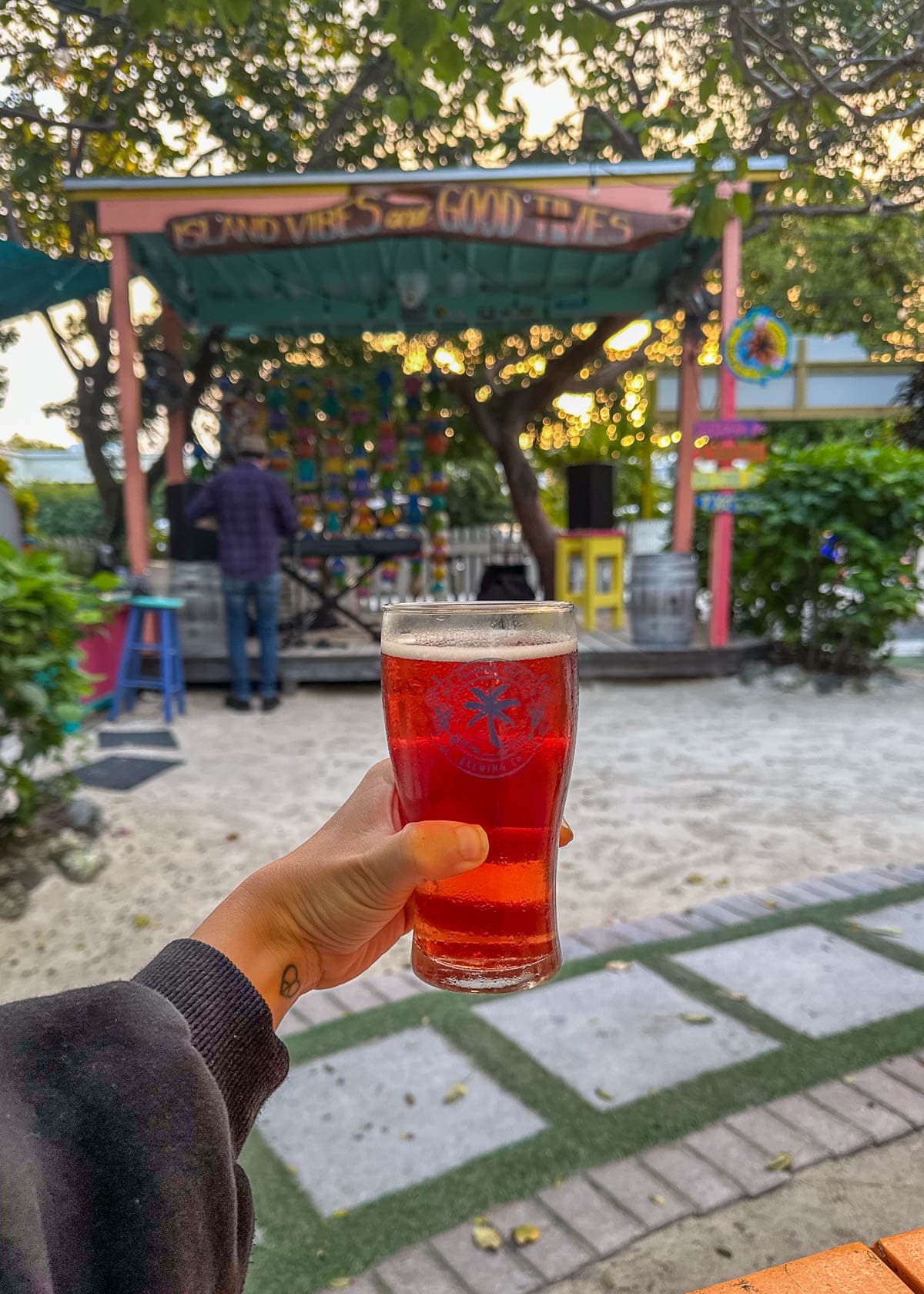 Woman holding a glass of beer in front of the stage at the Florida Keys Brewing in Islamorada in the Florida Keys, Florida 