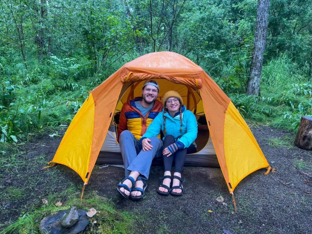 Smiling couple sitting in a tent in Brooks Camp Campground in Katmai National Park in Alaska