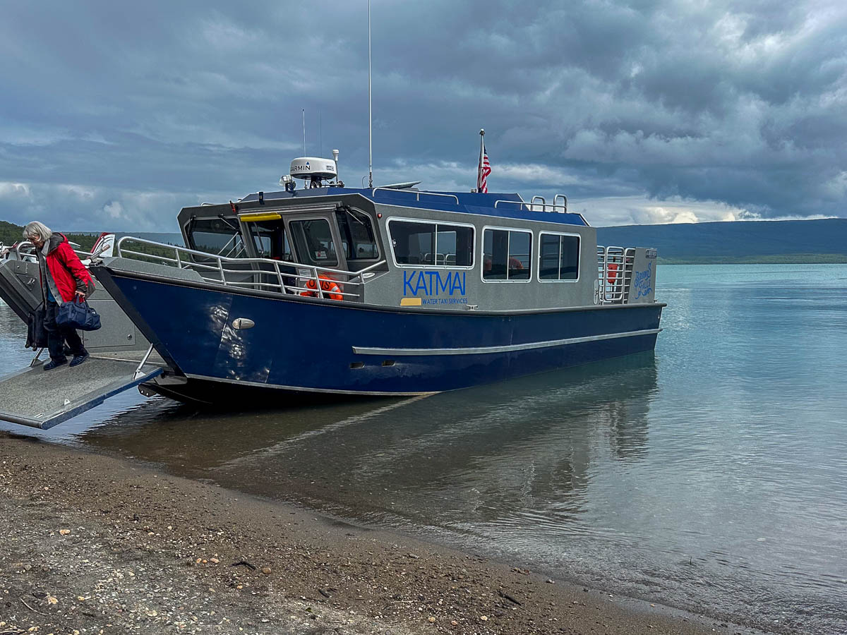 Woman exiting Katmai Water Taxi that is docked at Katmai National Park in Alaska