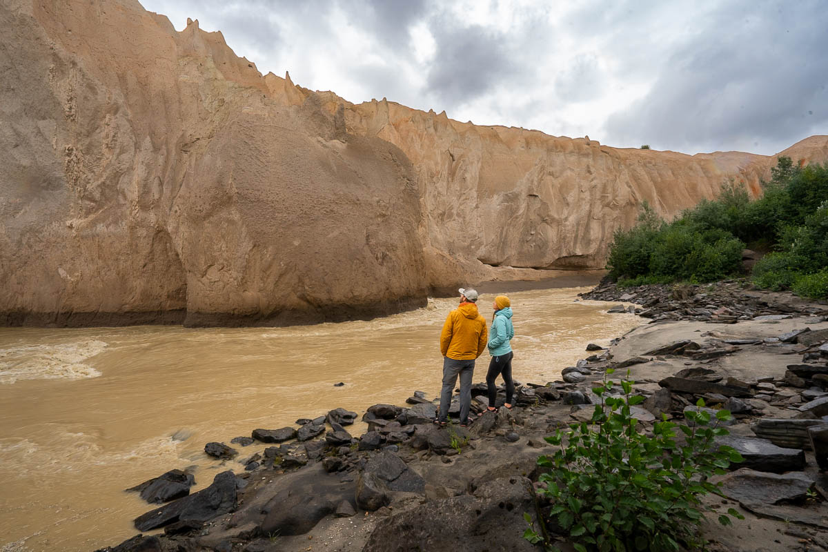 Couple looking at an ash wall near the Ukak River in the Valley of Ten Thousand Smokes in Katmai National Park