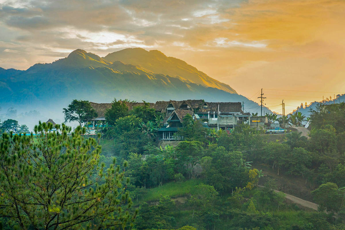 Buildings in front of mountains at sunset in Lanquin, Guatemala 