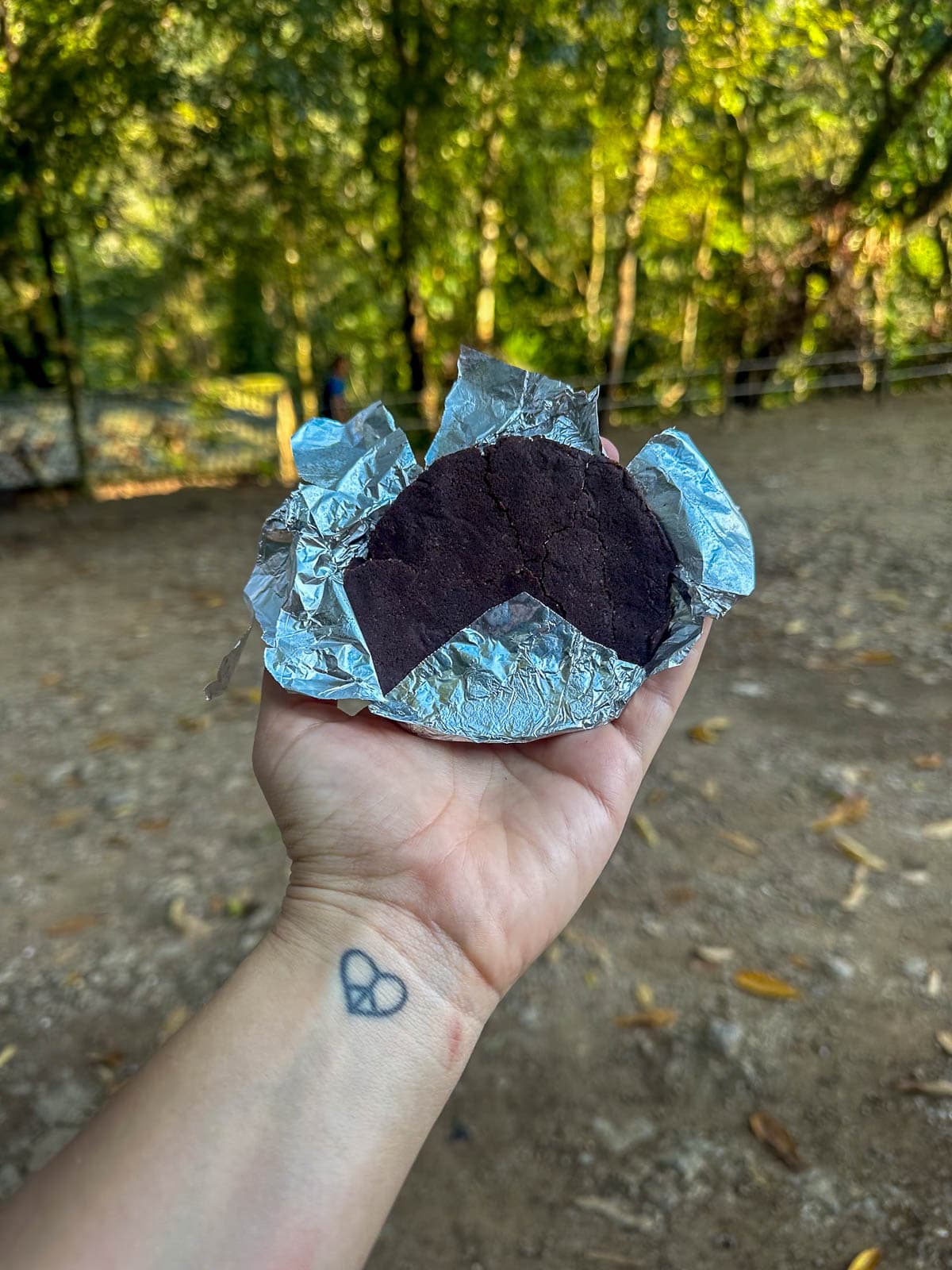 Woman holding a chocolate disc in front of Semuc Champey, Guatemala