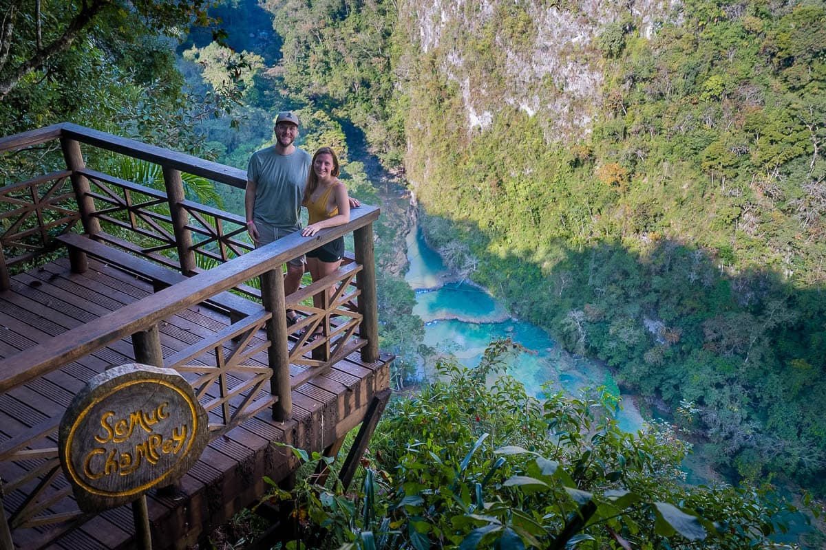 Couple standing on a wooden platform at the Mirador Semuc Champey in Guatemala 