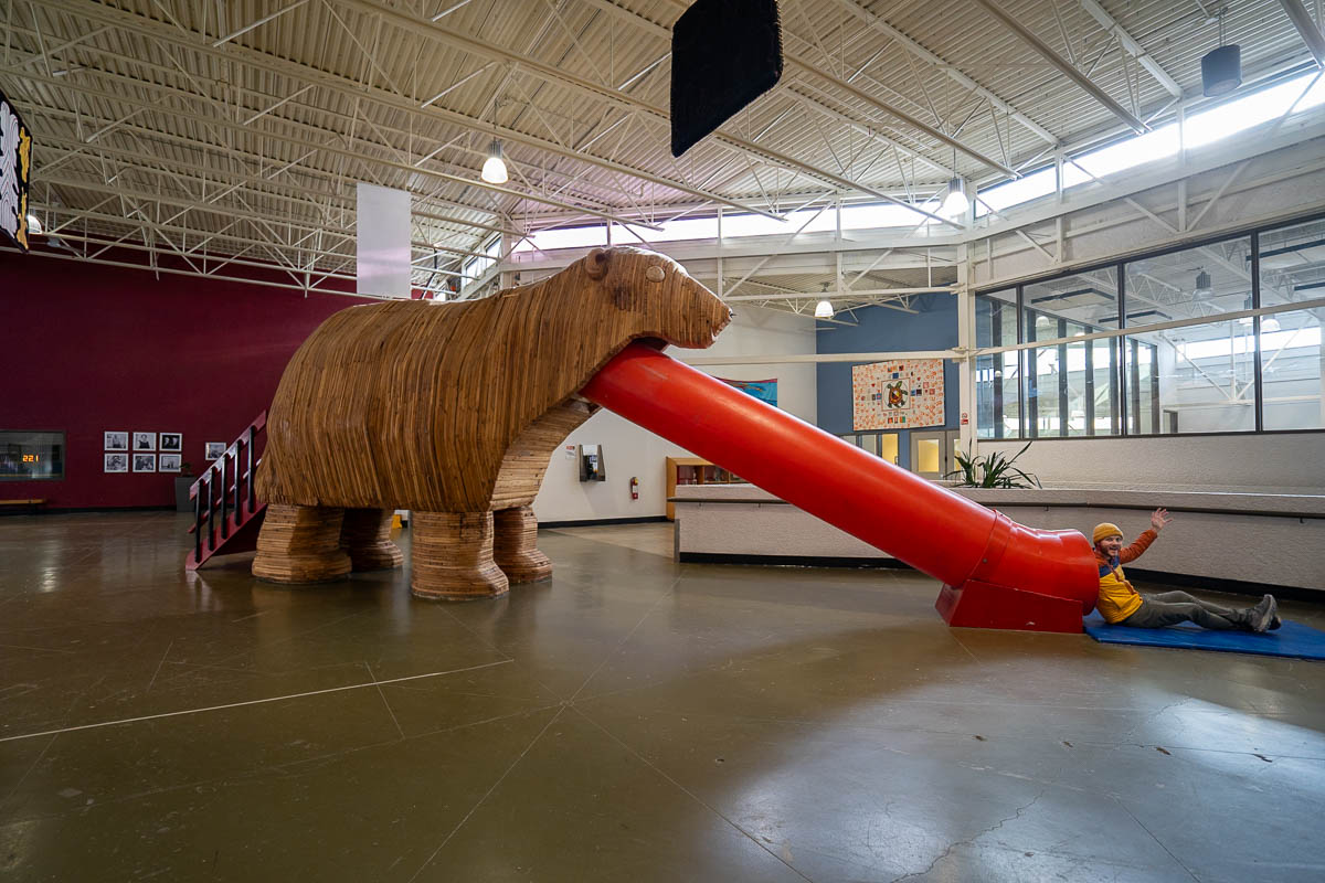 Man sliding down a wooden polar bear slide in the Churchill Town Centre Complex in Churchill, Manitoba