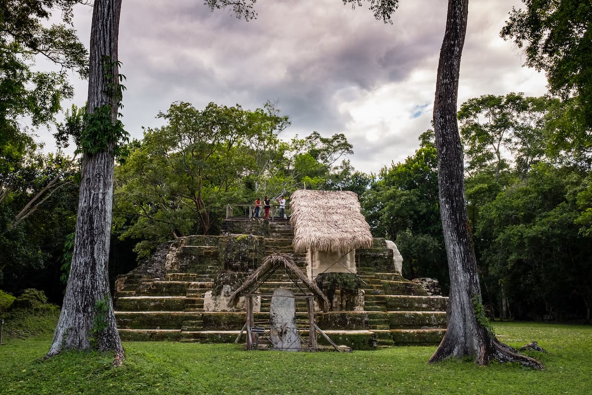 People standing on a pyramid in the Uaxactún Ruins in Guatemala