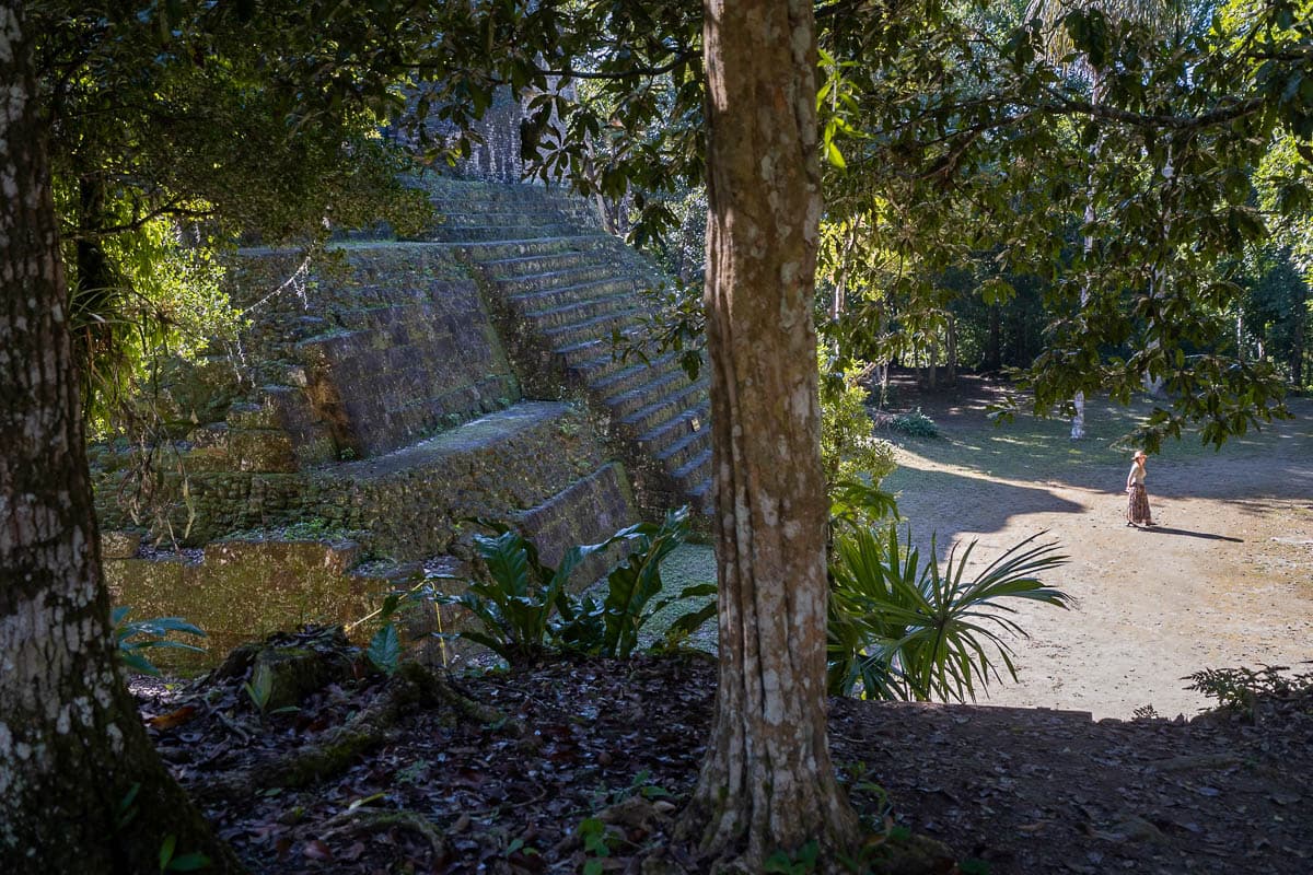 Woman walking away from a Mayan pyramid in Tikal, Guatemala