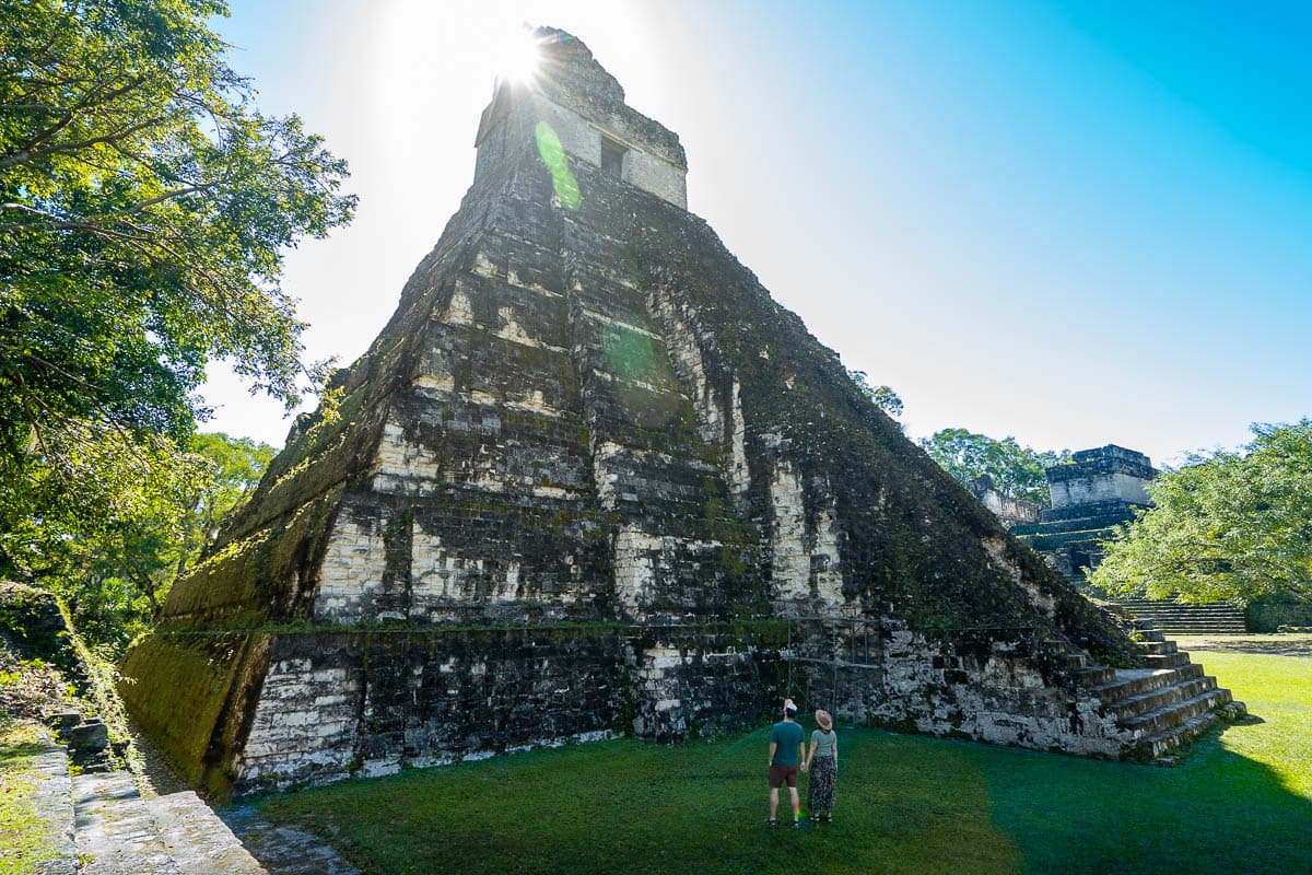 Couple holding hands in front of a Mayan pyramid in Tikal, Guatemala