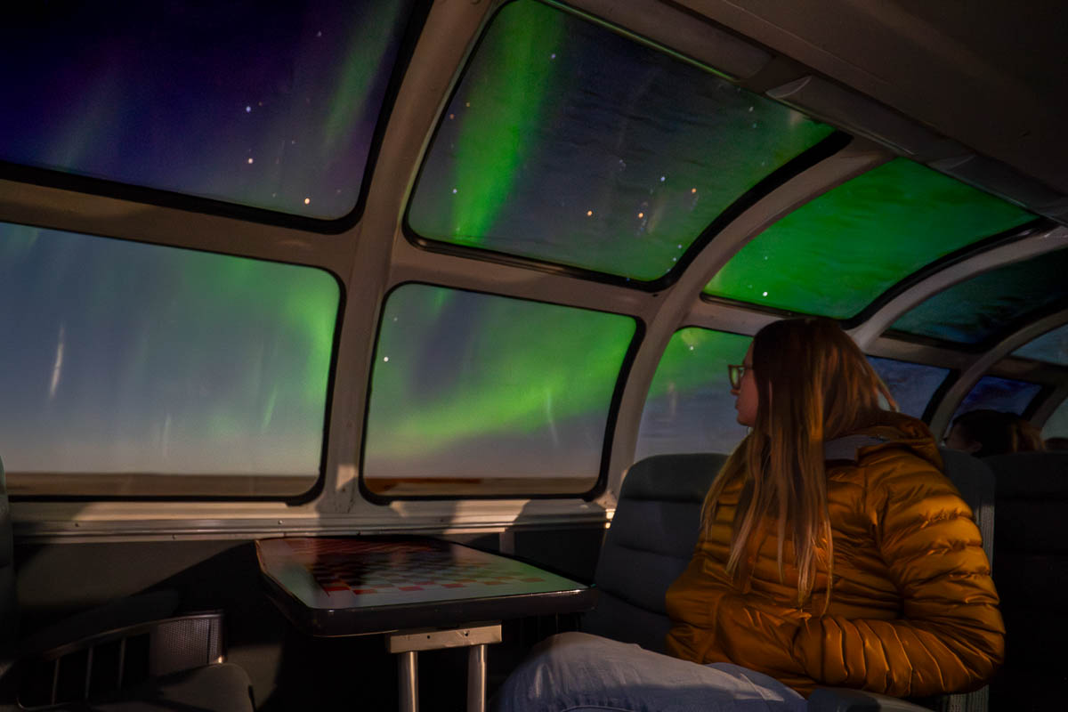 Woman sitting at a table on the Skyline Dome car on the Via Rail train to Churchill, Manitoba, Canada