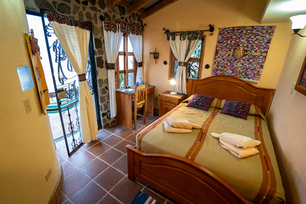 Bed, desk, and nightstand in an economy hotel room at Casa del Mundo on Lake Atitlan, Guatemala