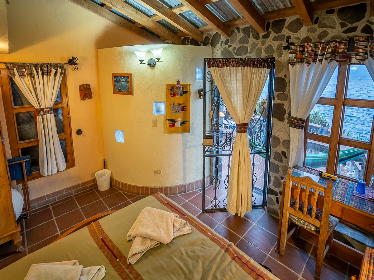 View of economy hotel with a window and hammock in the background at Casa del Mundo in Lake Atitlan, Guatemala