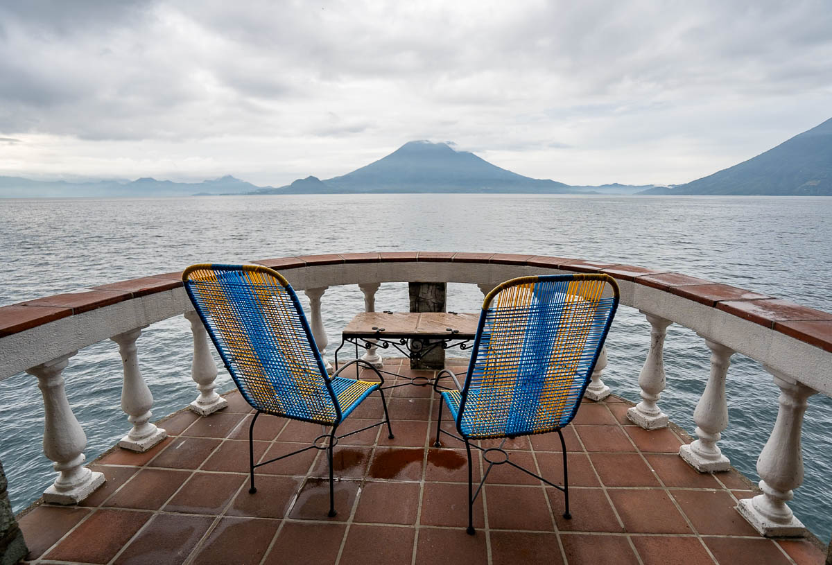 Chairs at a terrace overlooking volcanoes and Lake Atitlan at Casa del Mundo in Guatemala