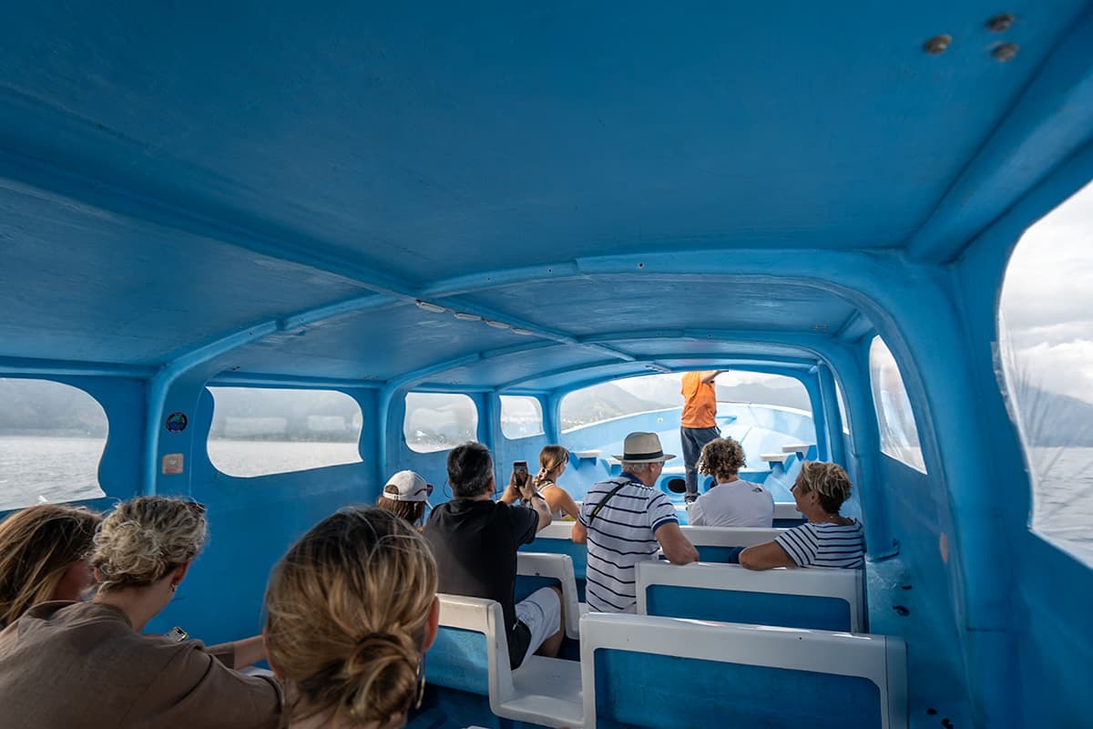 People sitting on a lancha driving across Lake Atitlan, Guatemala