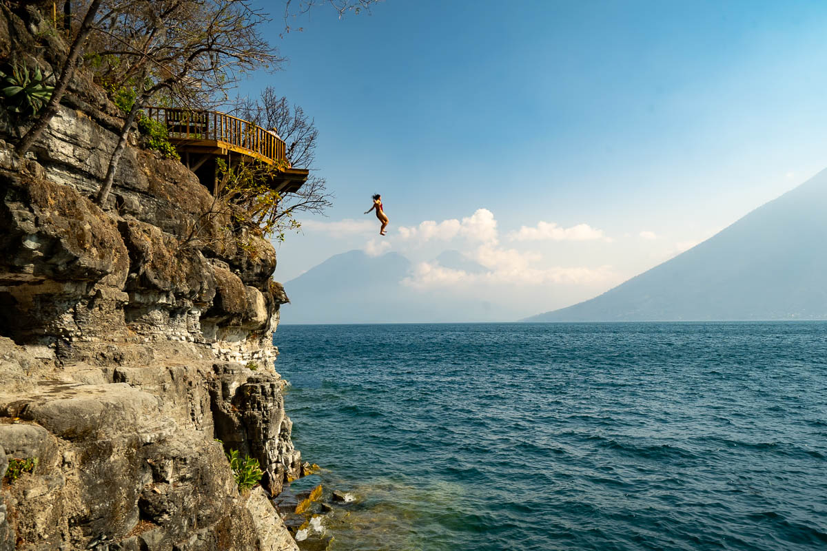 Woman jumping from a platform into Lake Atitlan in Reserve Natural Cerro Tzankujil in San Marcos, Guatemala