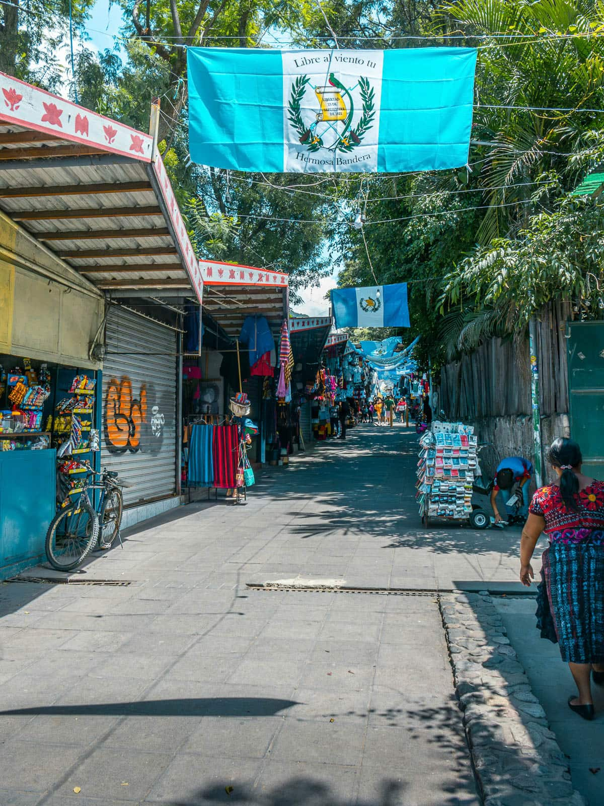 Vendors lining a street with Guatemalan flags hanging above in Panajachel, Guatemala