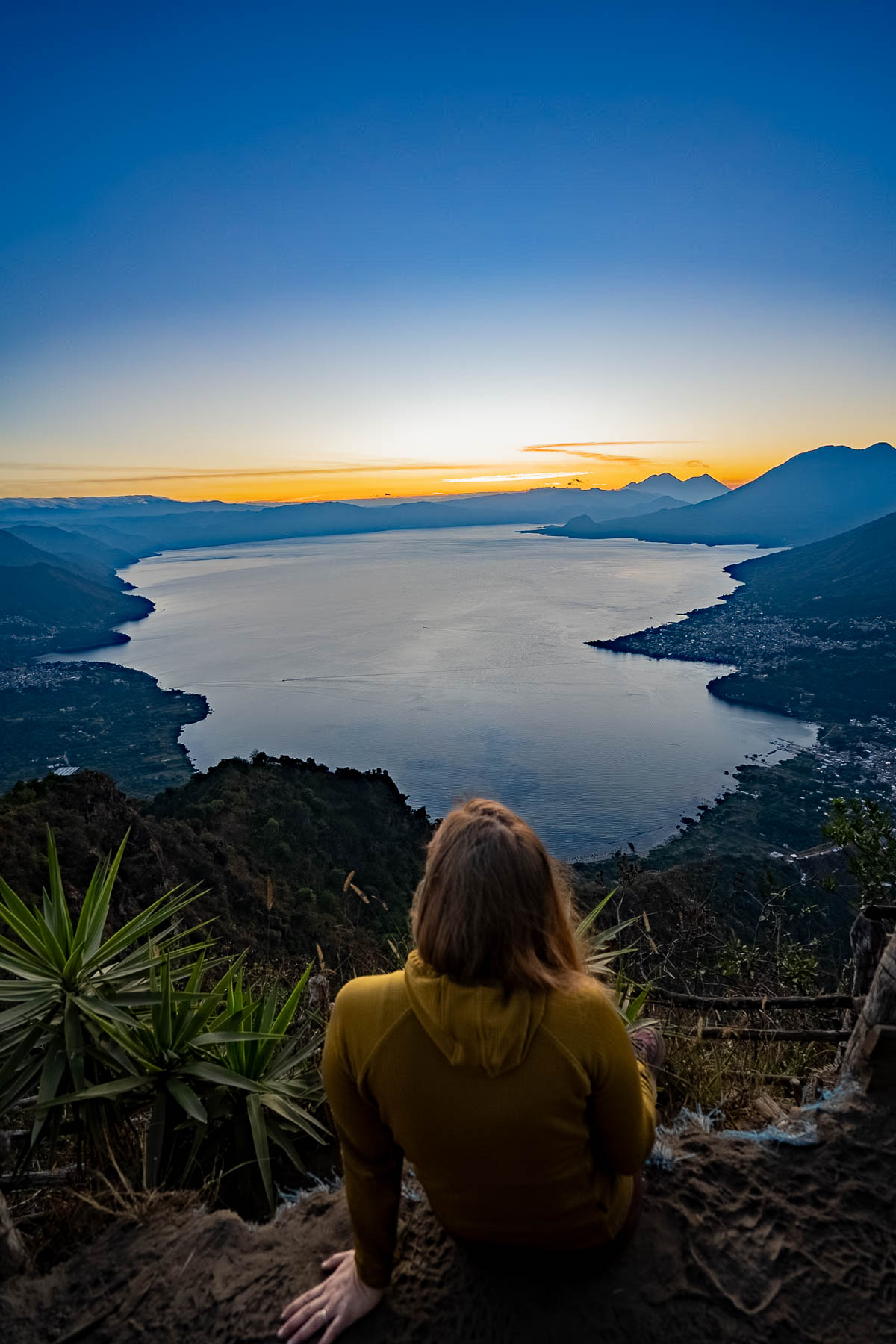 Woman sitting and overlooking Lake Atitlan at Indian Nose at sunrise in Guatemala