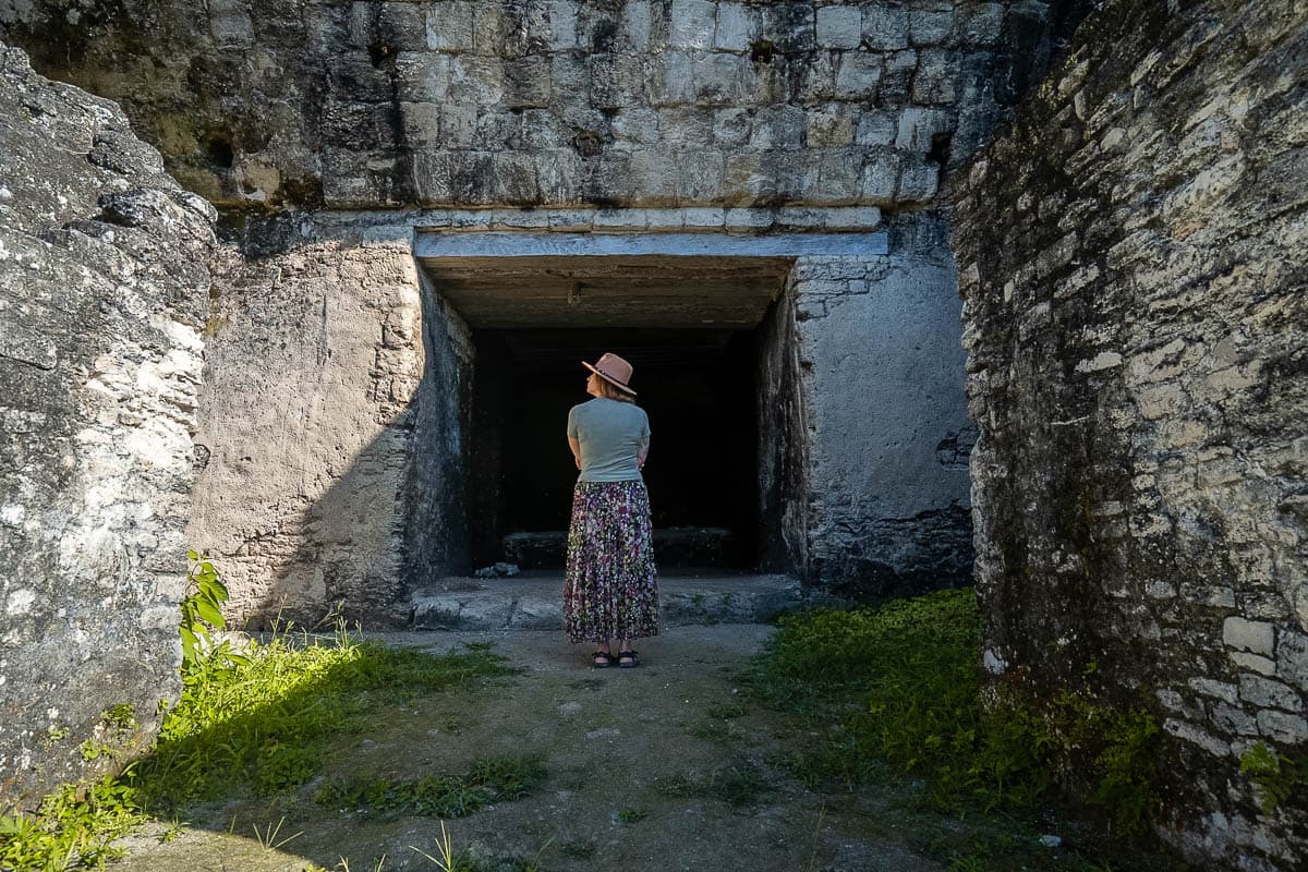 Woman standing in front of a chamber in a Mayan ruin at Tikal National Park in Guatemala