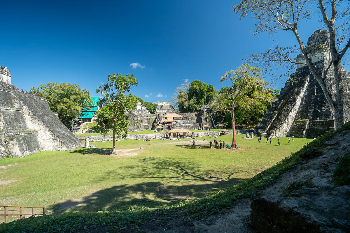 Tourists milling around the temples of the Grand Plaza in Tikal National Park in Guatemala