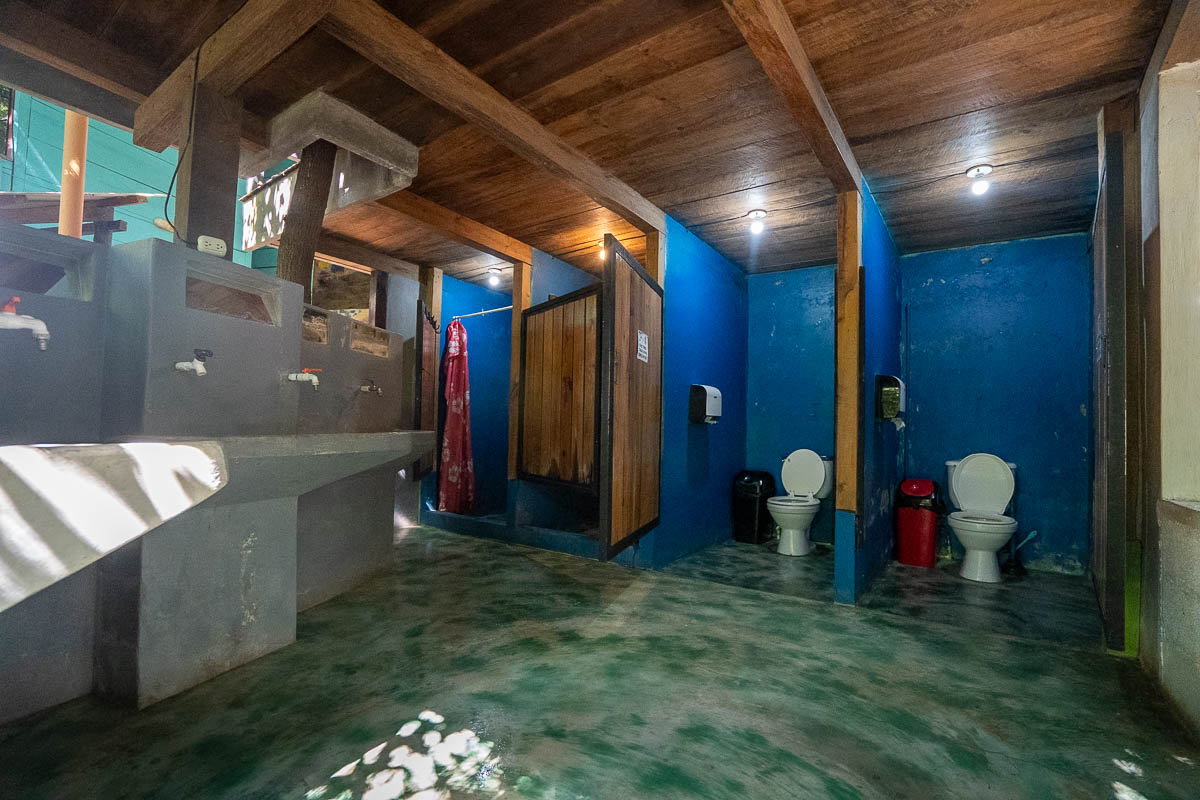 Shared bathroom with toilets, sinks, and showers at Greengos Hotel near Semuc Champey, Guatemala 